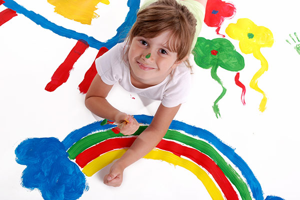 Young boy with brightly coloured painted hands